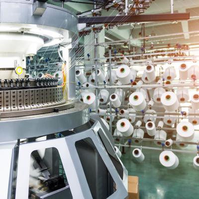 Textile industry - yarn spools on spinning machine in textile factory